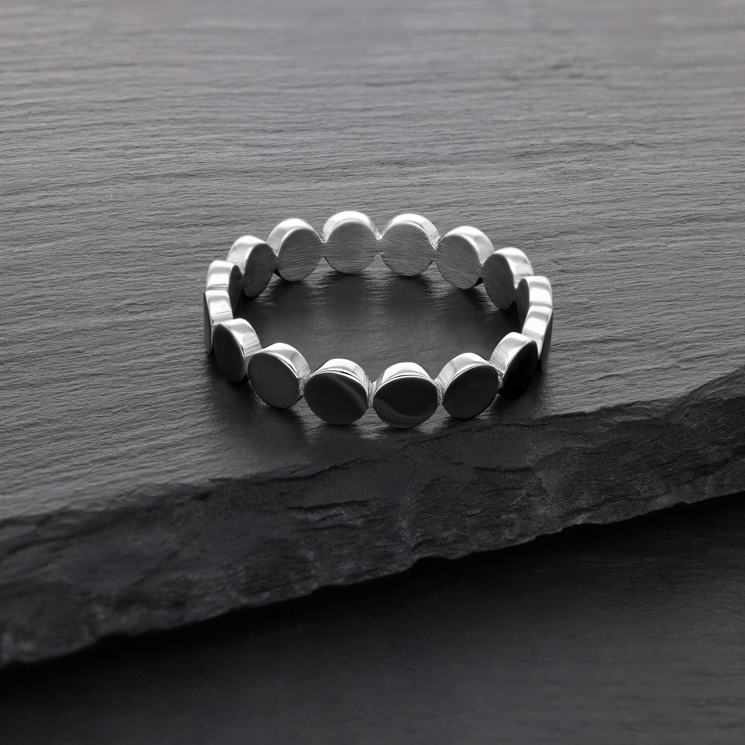 Silberner Ring aus Chirurgenstahl auf dunkler Steinoberfläche