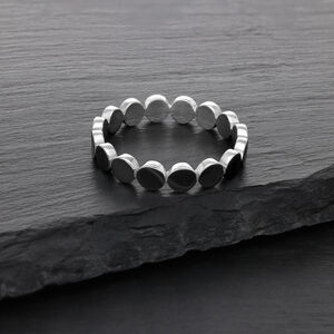 Silberner Ring aus Chirurgenstahl auf dunkler Steinoberfläche