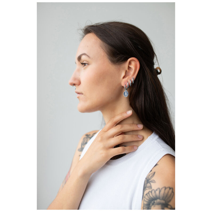 Mujer con aros Mystic Snake plateados, perfil lateral, camiseta blanca