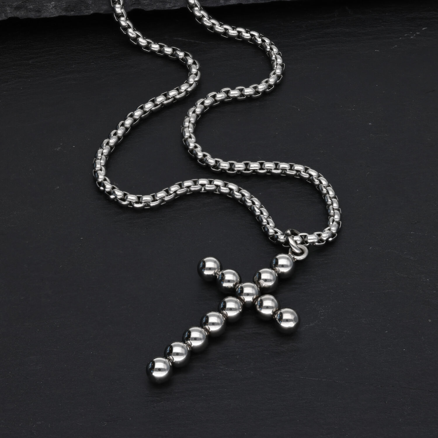 Bubble Cross Halskette aus Chirurgenstahl Silberne Kreuzkette mit Kugeldesign auf schwarzem Hintergrund