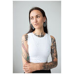 Mujer con brazos tatuados lleva pendientes Monstera Leaf Hoops, camiseta blanca