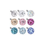 Nove accessori rotondi e multicolori con cristalli su sfondo bianco