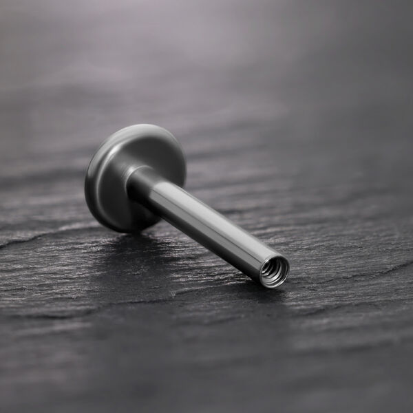 Labret de titanio negro con rosca interna sobre fondo negro
