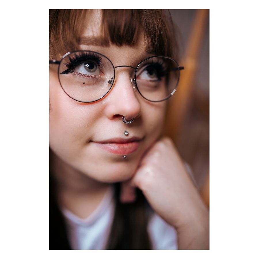 Mujer con piercing nasal, cristal y bolas, sonriendo