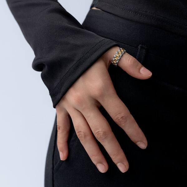 Hand mit schwarzem Ärmel greift in die Hosentasche, trägt Silber-Gold Ring