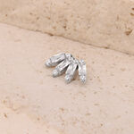 Accesorio Push Fit plateado con cristales en forma de baguette sobre superficie de piedra beige