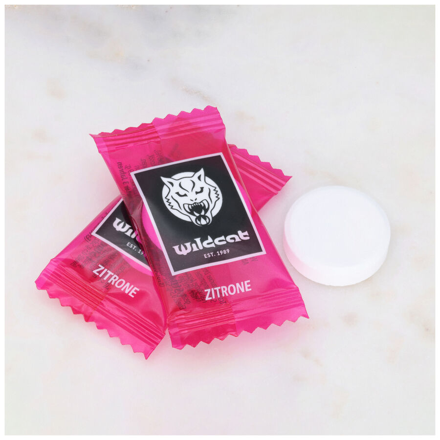 Zwei pinke Wildcat Zitronen-Dextrosetabletten auf Marmorhintergrund
