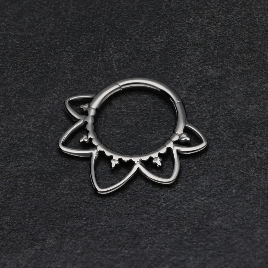 Clicker de septum negro en forma de flor sobre fondo oscuro
