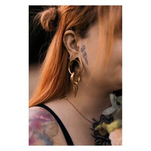Goldener Monstera Push-Fit Labret im Ohr Frau mit rotem Haar trägt goldenen Monstera Push-Fit Labret im Ohr, Tattoos sichtbar