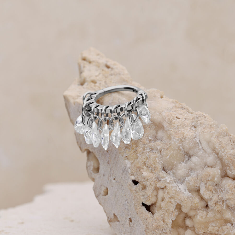 Anello piercing in argento con cristalli chiari su sfondo beige