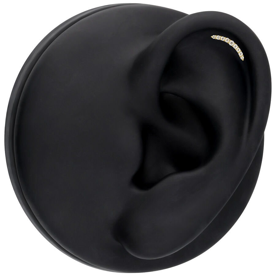 Inserto dorato con cristalli di moissanite in un display nero per orecchio