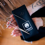 Astuccio nero con logo Wildcat, due aghi e forbici, tenuto in mano