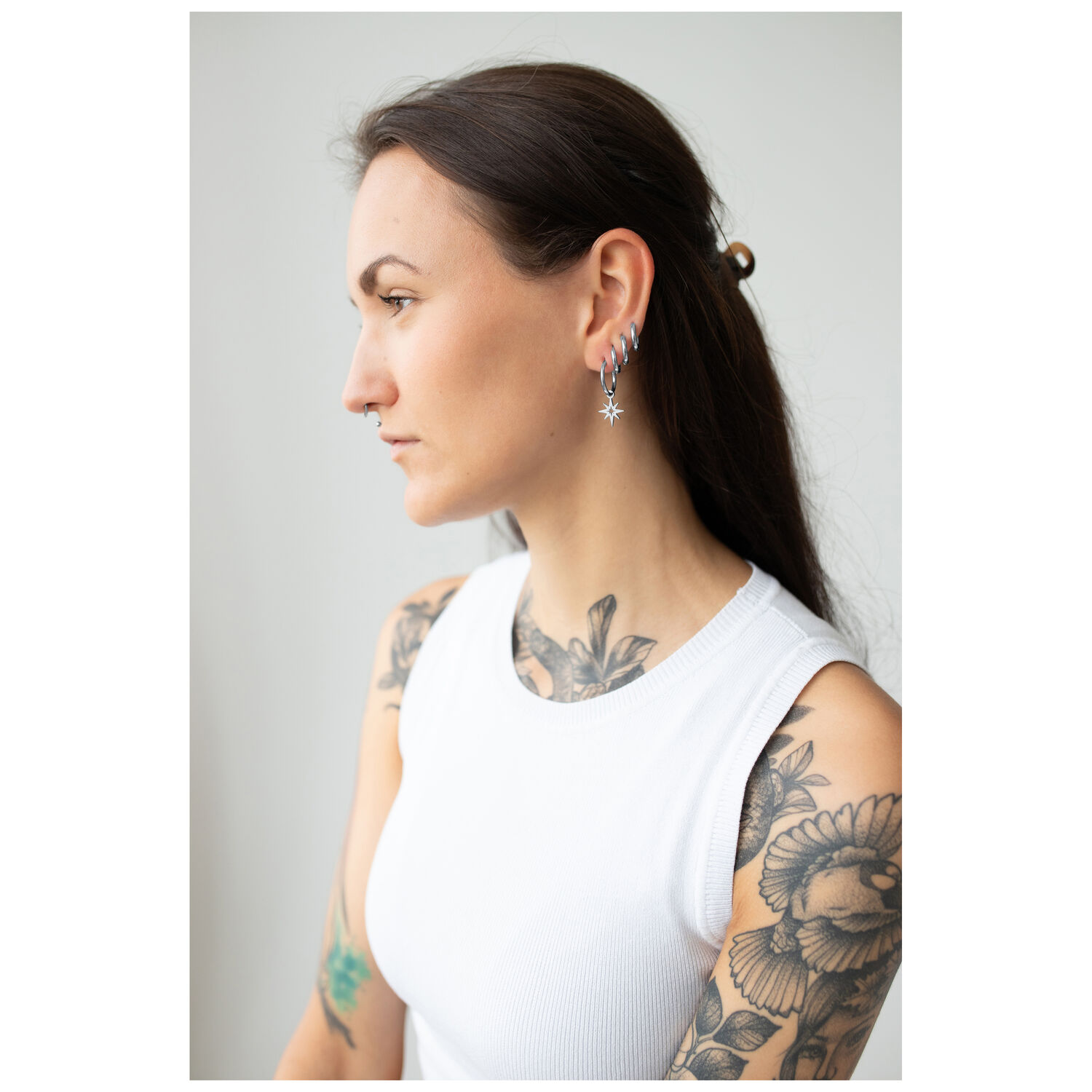 Elegante Little Polar Star Hoops in Silber Frau mit silbernen Little Polar Star Hoops vor hellem Hintergrund
