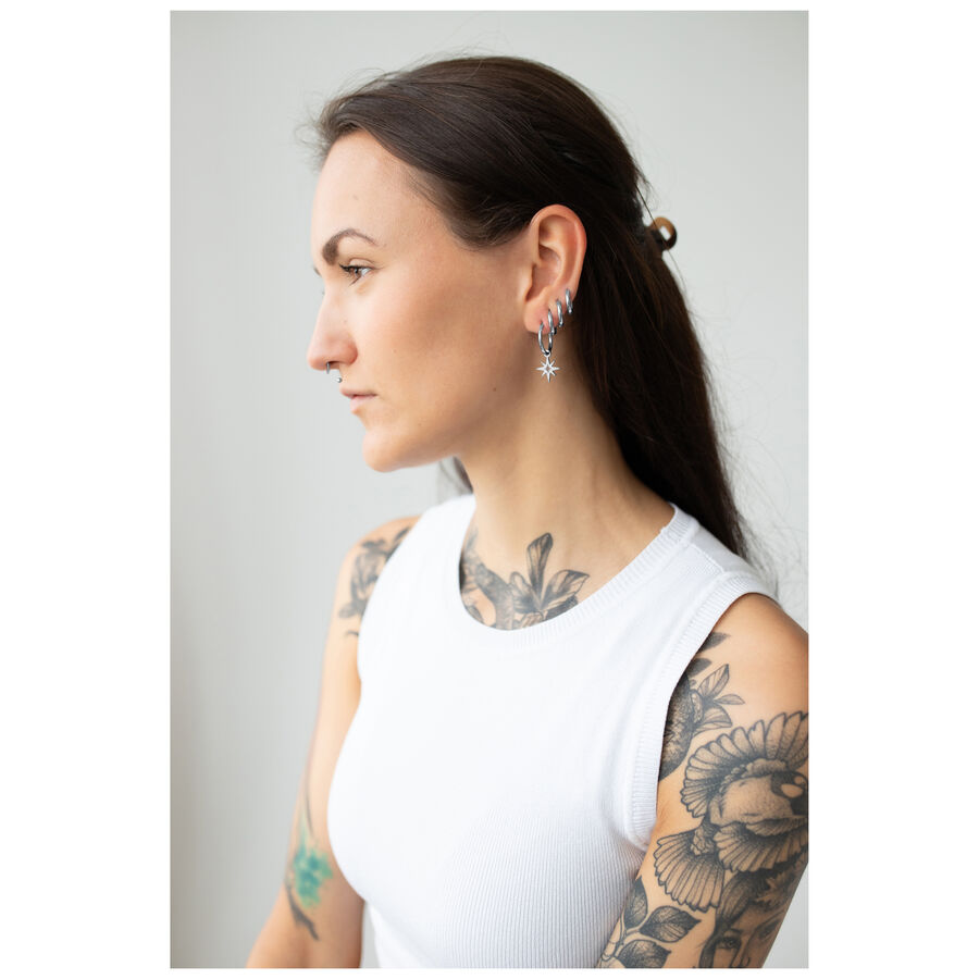 Donna con Little Polar Star Hoops in argento su sfondo chiaro