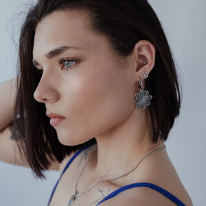 Elegante Fine Flower Hoops in Silber Frau mit kurzen Haaren trägt silberne Fine Flower Hoops vor grauem Hintergrund
