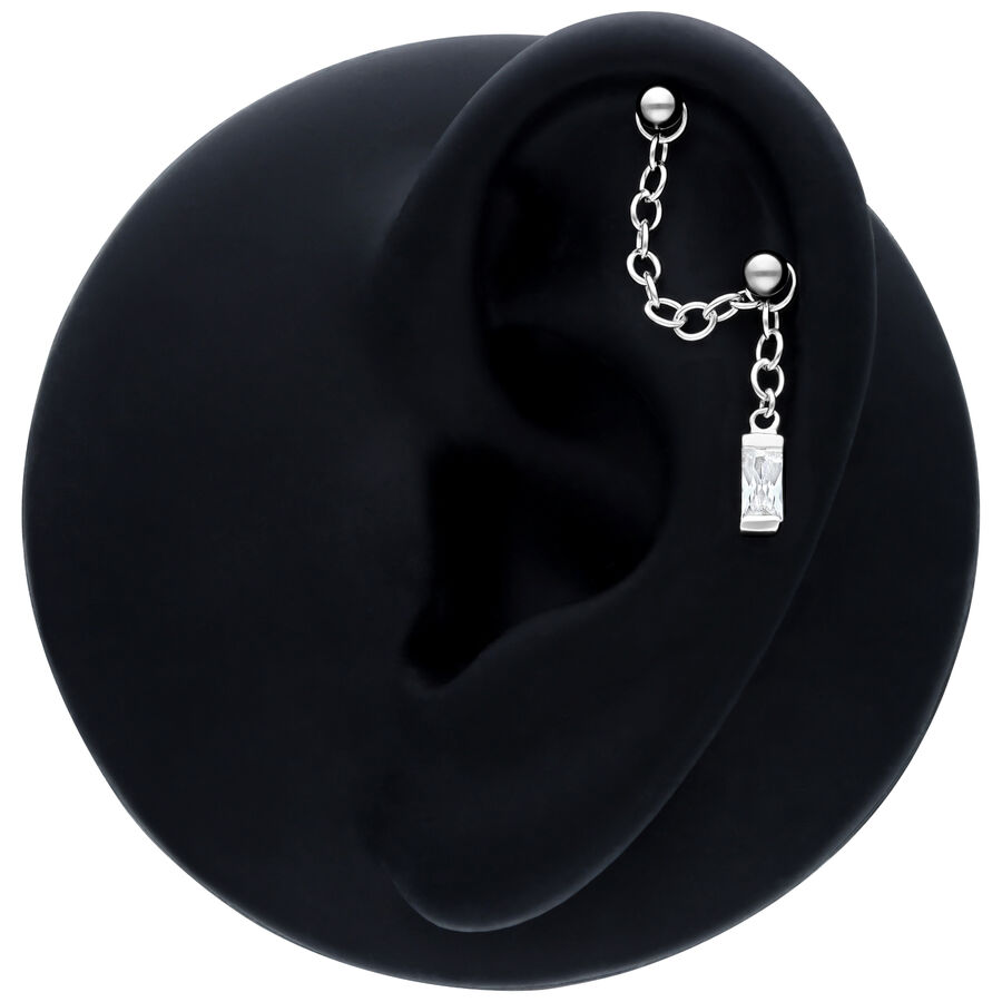 Schwarze Piercingkette mit Hänge-Baguette-Kristall an einem Ohrmodell