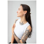 Mujer con cabello largo lleva estilosos pendientes Little Flower Hoops sobre fondo gris