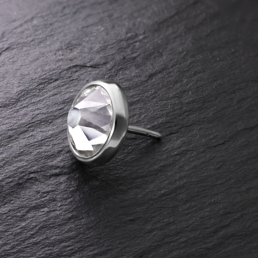 Disco plateado para Triple Piercing con cristal claro sobre fondo oscuro