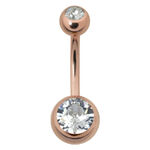 Piercing all'ombelico in oro rosa con due pietre cristalline su sfondo bianco
