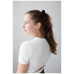 Donna con capelli lunghi indossa orecchini Little Lock Hoops in argento su sfondo bianco