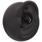 Accessorio nero per piercing all'orecchio con piccole sfere argentate su sfondo nero