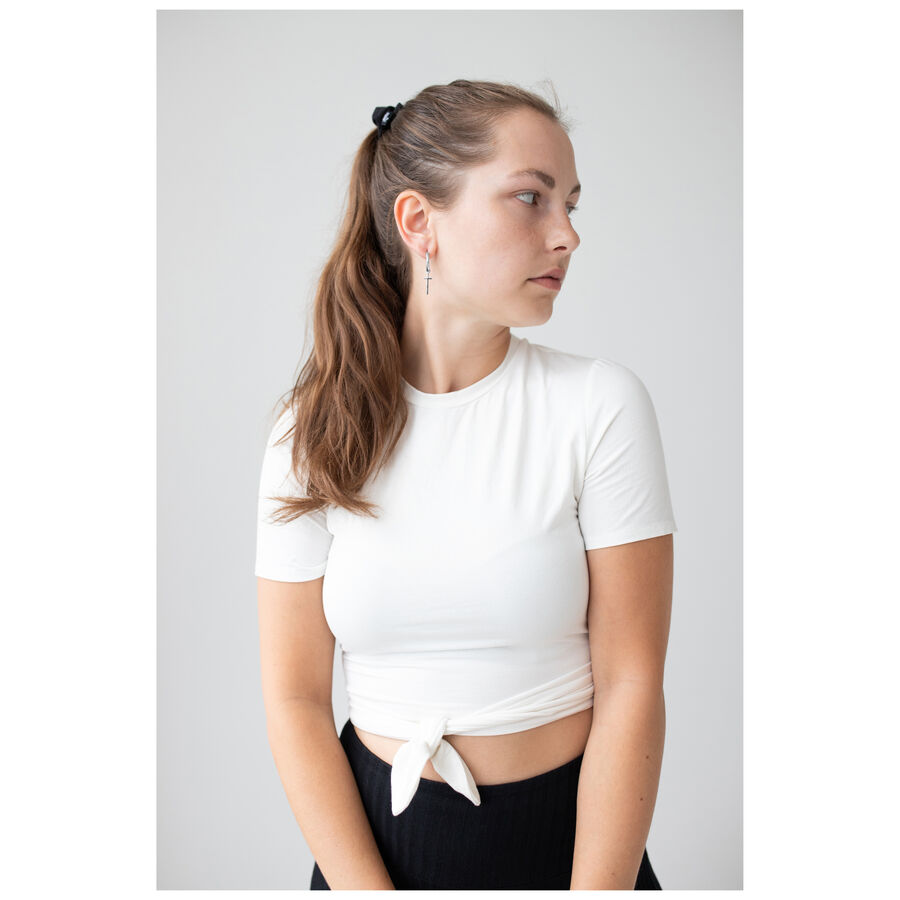 Mujer con pendientes Little Cross Hoops, camiseta blanca, de lado