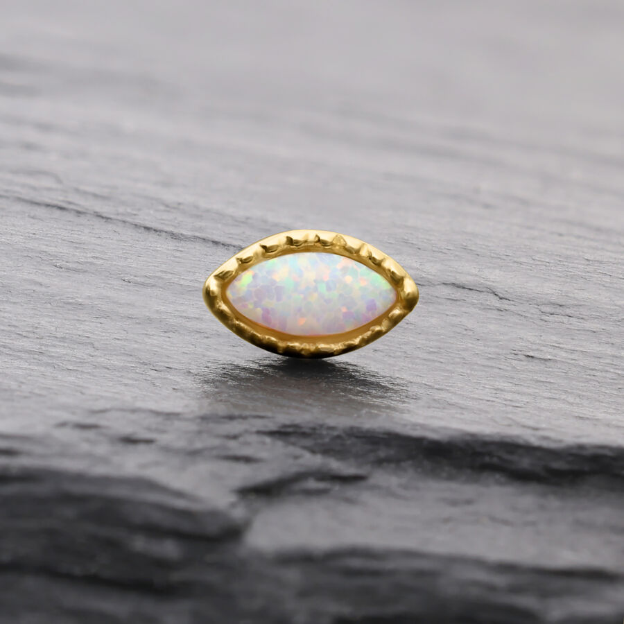 Ovaler synthetischer Opal in goldener Fassung auf grauem Hintergrund