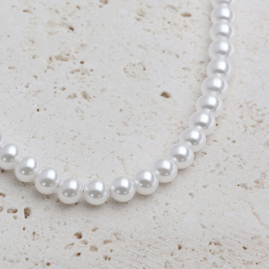 Collana di perle sintetiche argento su sfondo di pietra chiara