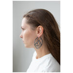 Donna con capelli lunghi indossa grandi orecchini Lotus Hoops neri