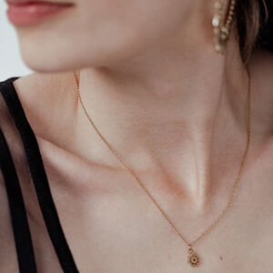 Goldene Little Sunflower Kette für Damen Dame mit goldener Little Sunflower Kette, filigran und elegant, auf hellem Hintergrund