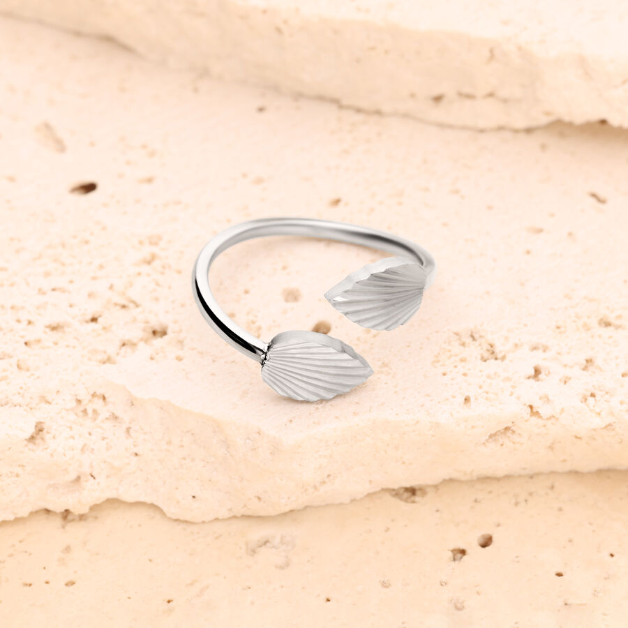 Silberner Ring mit zwei geriffelten Blättern auf hellem Steinuntergrund
