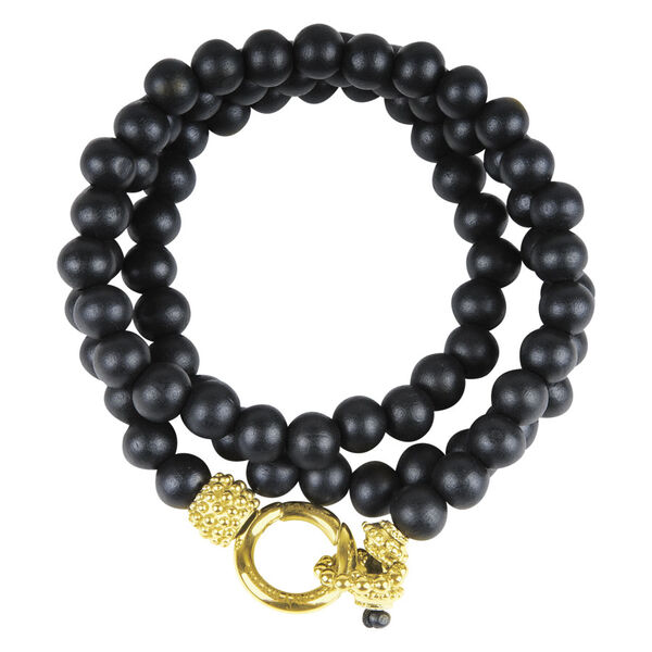 Pulsera negra de cuentas de madera con cierre dorado sobre fondo blanco