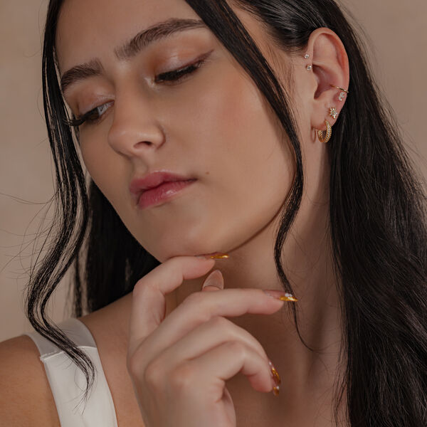 Mujer con 14K Gold Crystal Hinged Ring y otros pendientes en la oreja