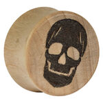 Plug de madera con calavera negra sobre madera natural, vista frontal