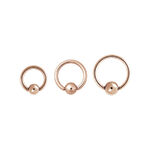 Tres anillos clip en de oro rosa de acero quirúrgico sobre fondo blanco
