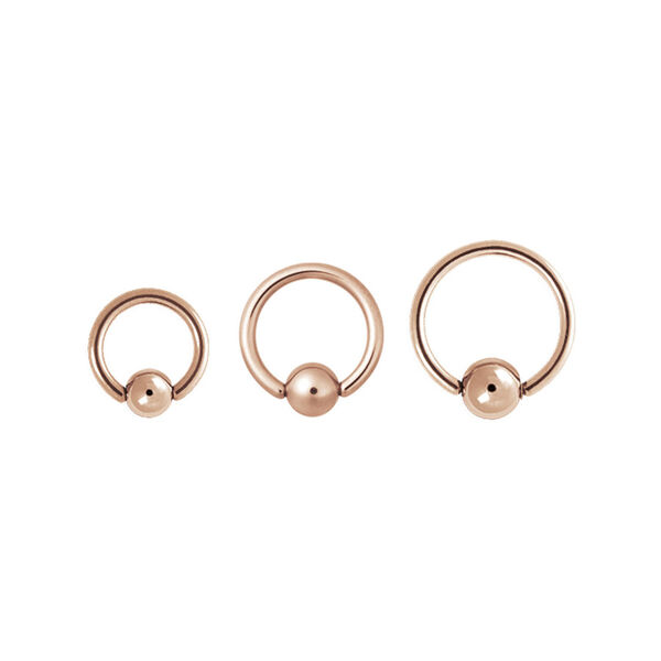 Tres anillos clip en de oro rosa de acero quirúrgico sobre fondo blanco