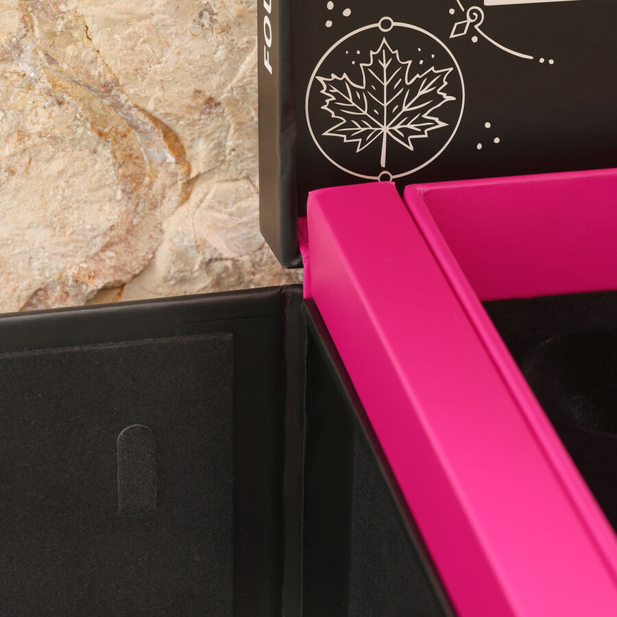 Dettaglio di un calendario dell'Avvento con cornice interna rosa e parte esterna nera davanti a un muro di pietra