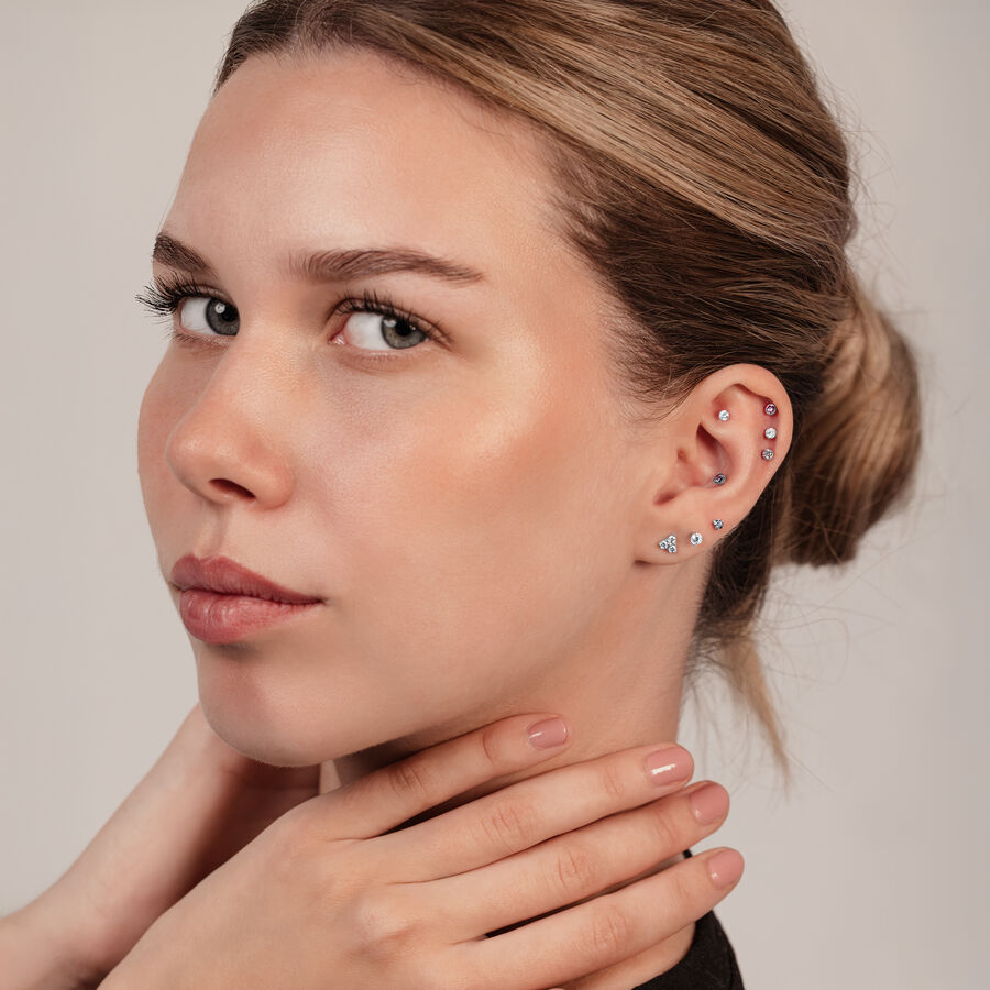 Mujer con piercing de accesorio Trinity para rosca interna en la oreja