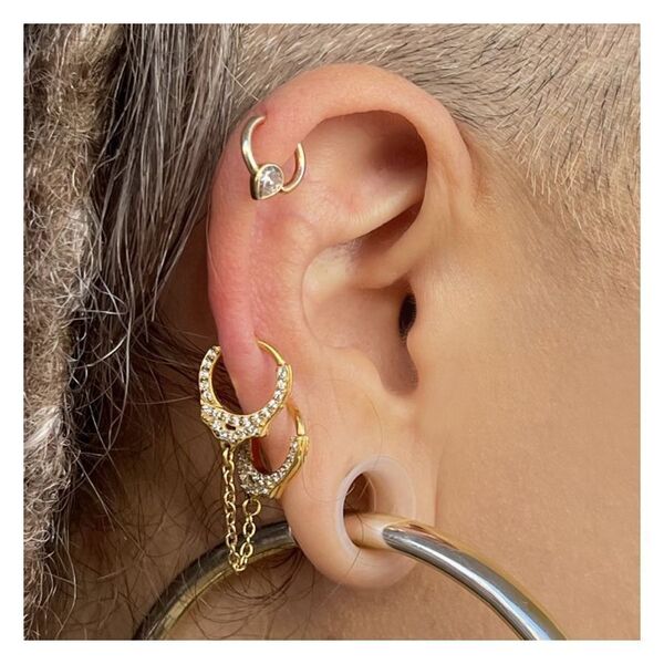 Goldene Helix-Piercings am Ohr mit kurzen Ketten und funkelnden Steinen