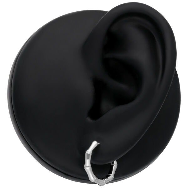 Pendientes de bambú plateados en modelo de oreja negra sobre fondo neutro