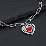 Bracciale color argento in acciaio chirurgico con ciondolo a cuore rosso su sfondo scuro