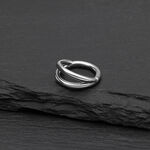 Anillo clicker de doble fila de plata de titanio sobre fondo negro