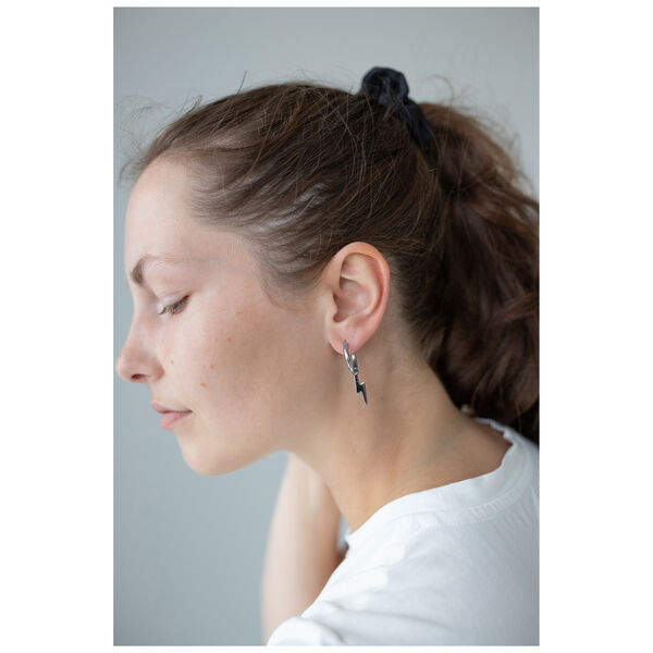 Donna con coda nera indossa orecchini Little Flash Hoops in acciaio chirurgico