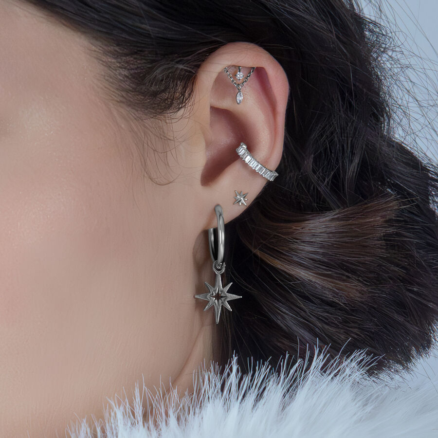 Helix de plata con cristales en una oreja, fondo oscuro