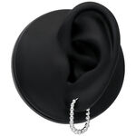 Silberne Oval Bubble Hoops am schwarzen Ohr auf neutralem Hintergrund