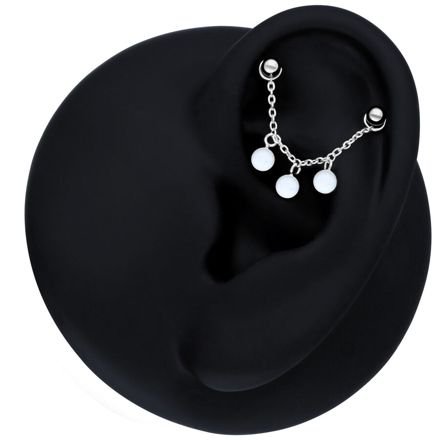 Schwarze Piercingkette mit synthetischem Opal am Ohr auf schwarzem Hintergrund