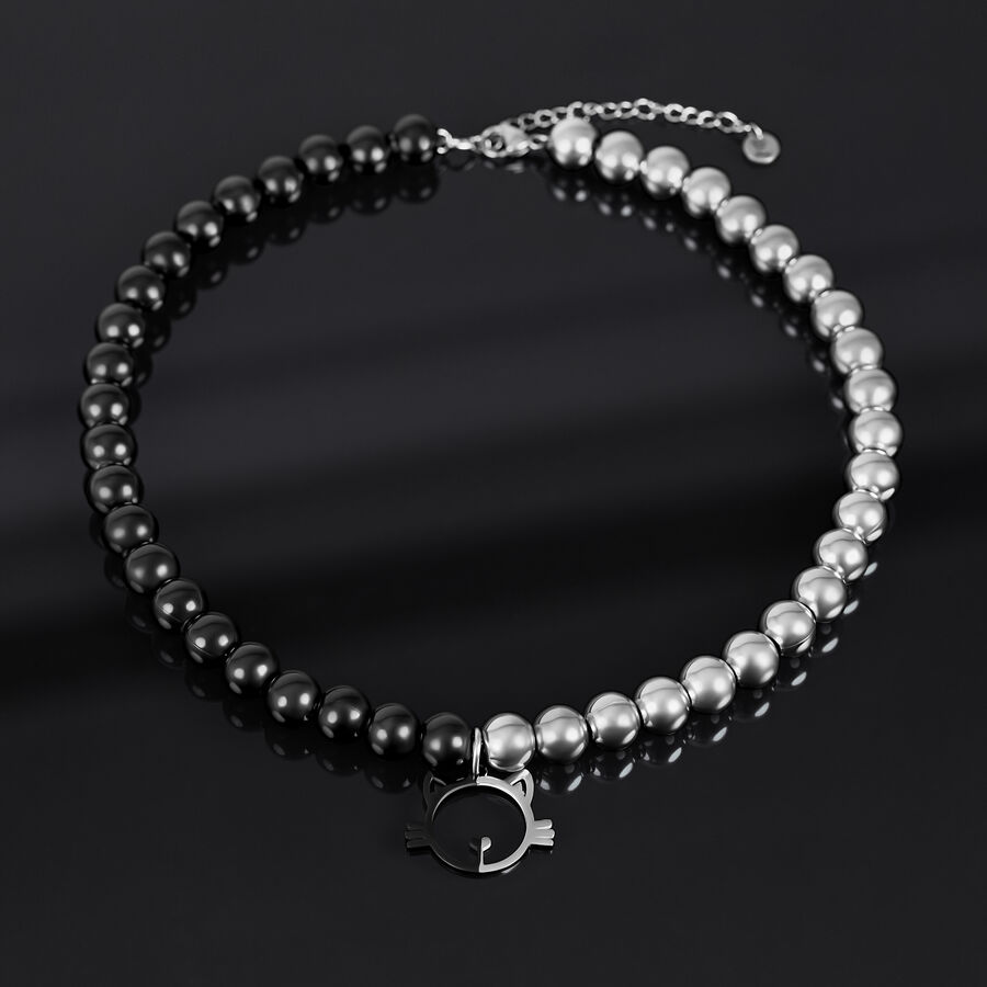 Collana con perle argento e nere e ciondolo a forma di gatto su sfondo scuro