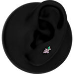 Accesorio de piercing plateado en forma de uva con piedras moradas y verdes en un modelo de oreja negra