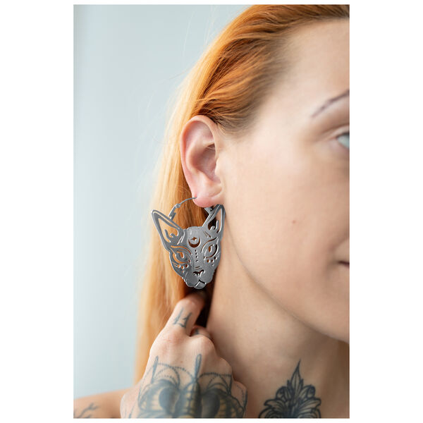 Orecchini Sphynx Hoops in argento su un orecchio con mano tatuata
