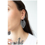 Mujer con pendientes Creek Hoops en plata, llevados en la oreja, fondo blanco